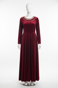 Red velvet gown on mannequin with plain background
